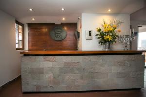 a lobby with a counter with flowers and a clock at Atoq San Blas Hotel in Cusco