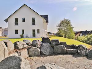 uma casa com uma parede de pedras em frente em FeWo ODEM em Gladenbach