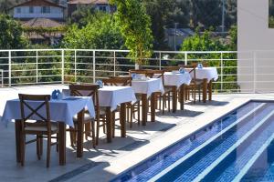a row of tables and chairs next to a swimming pool at Highclere Hotel and Spa in Faralya