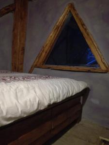 una cama en una habitación con ventana en La Torre, en San Carlos de Bariloche