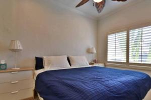 1 dormitorio con 1 cama azul y ventilador de techo en 1000#2 Magnificent Beach Home w/ AC & 4K TVs, en Newport Beach