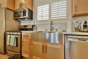 uma cozinha com um lavatório de aço inoxidável e um fogão em 1000#2 Magnificent Beach Home w/ AC & 4K TVs em Newport Beach