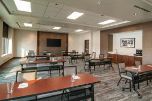una sala conferenze con tavoli, sedie e schermo di Hyatt Place Sioux Falls South a Sioux Falls