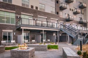 an apartment building with a staircase and tables and chairs at Hyatt Place Sioux Falls South in Sioux Falls