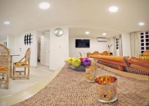 a living room with a table with a bowl of fruit at HominngBird Acapulco in Acapulco