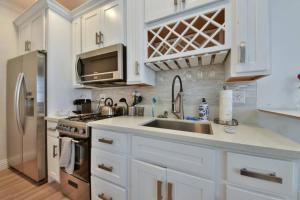 a white kitchen with a sink and a refrigerator at 1000#3 Renovated Home by Beach & Sand - AC & More! in Newport Beach