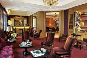 a living room filled with furniture and a chandelier at Villa Lara Hotel in Bayeux