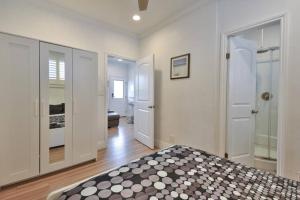 1 dormitorio con paredes blancas y 1 cama de color negro en 1000#4 Modern Beach Home, Steps from Sand w/AC! en Newport Beach