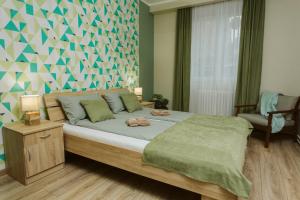 1 dormitorio con 1 cama grande con manta verde en Vively Lux Apartment, en Subotica