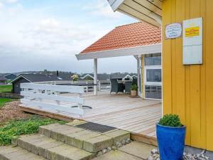 una terrazza in legno con tavolo e panca su una casa di 8 person holiday home in Nordborg a Nordborg