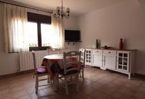 a dining room with a table and chairs and a television at Apartamentos Barrena in Albarracín