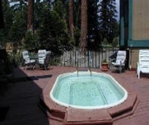 una bañera de hidromasaje en un patio con sillas y una valla en Crestview -B # 46, en Mammoth Lakes