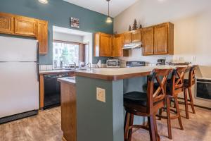 a kitchen with wooden cabinets and a white refrigerator at Helios S # 5 in Mammoth Lakes