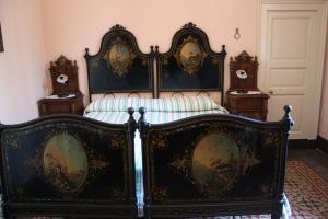 an ornate bed in a room with two tables at B&B Sotto i Pini in Zafferana Etnea