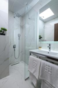 a white bathroom with a shower and a sink at Euro Hotel Gradche in Kočani