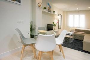 een woonkamer met een glazen tafel en witte stoelen bij NEW AND COZY-STUDIO-CHUECA in Madrid