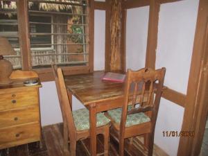 mesa de comedor de madera con 2 sillas y escritorio en Cerros Beach Inn, en Corozal