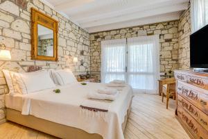 ein Schlafzimmer mit einem großen Bett und einem Fernseher in der Unterkunft Ev Bharat Butique Hotel, Alaçatı in Alacati + 34 Fotos