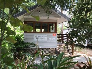 a tiny house with a sign on the door at Dandaloo Gardens in Arcadia