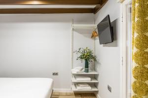 Habitación con cama y TV. en BNBHolder Rustic Group GRAN VÍA & SOL en Madrid