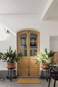 drewniane drzwi z dwoma doniczkami przed nimi w obiekcie Casa La Aldaba w mieście Montejaque