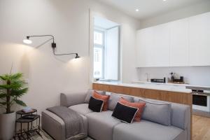 uma sala de estar com um sofá e uma cozinha em FLH Praça Comércio Tropical Flat em Lisboa