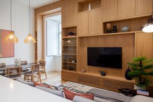 uma sala de estar com um grande centro de entretenimento com televisão em FLH Praça Comércio Tropical Flat em Lisboa