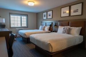 Una habitación de hotel con dos camas y una ventana. en Best Western Gold Rush Inn, en Whitehorse