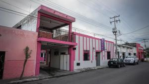 un edificio rosa al lado de una calle en Hotel D´Concepción, en Tizimín