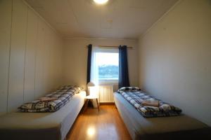 two beds in a room with a window at Mary Rooms in Tromsø