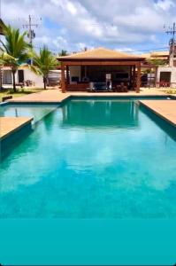 einen Pool mit blauem Wasser vor einem Haus in der Unterkunft Apartamento em barra grande - Villaggio di Mare - apto 02 bl 04 - Garden in Barra Grande