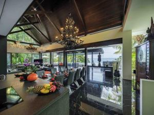 Un comedor con una mesa y sillas y una lámpara de araña. en Villa Yang, Private Oceanfront Villa, Kamala Beach, en Kamala Beach