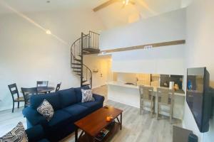 a living room with a blue couch and a kitchen at Brand New! MountainCreek SlopeSide Condo,Golf,&Spa in Sand Hills