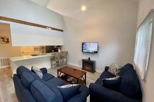 a living room with blue couches and a tv at Brand New! MountainCreek SlopeSide Condo,Golf,&Spa in Sand Hills