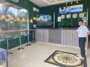 a young boy standing in a restaurant with a pizza at Seeds Hotel Wangsa Maju in Kuala Lumpur