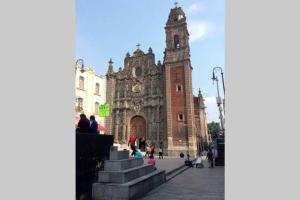 une vieille église avec une tour d'horloge dans une ville dans l'établissement La Santísima, à Mexico