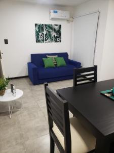 sala de estar con sofá azul y mesa en Costanera.VM en Villa María