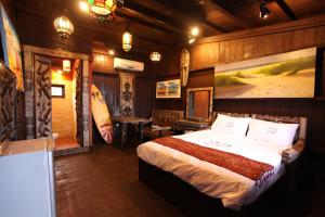 a bedroom with a large bed in a room at Kenting Afei Surf Hostel Jialeshuel Nanu in Manzhou