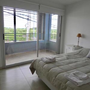 1 dormitorio con cama grande y ventana grande en Departamento en Luján de Cuyo, Perfecta ubicación para visitar viñedos! en Luján de Cuyo