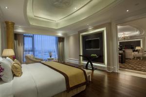 a bedroom with a large bed and a living room at Holiday Inn Foshan Nanhai Central, an IHG Hotel in Foshan