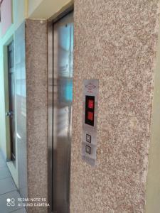 ホーチミン・シティにあるKhách sạn Hoa Anh Anhの壁の隣の建物内の金属製エレベーター