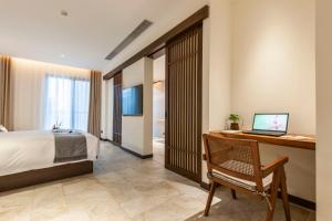 a bedroom with a bed and a desk with a computer at SSAW Boutique Hotel Hangzhou Liangyun in Hangzhou