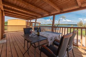 una terraza de madera con una mesa con copas de vino. en Mobile home Sea Bream, en Pašman