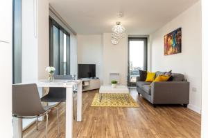 uma sala de estar com um sofá e uma mesa em The Exclusive Apartment em Manchester