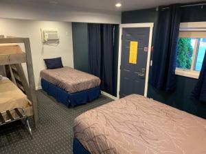 um quarto com duas camas e uma porta com uma janela em Peaks Lodge em Revelstoke