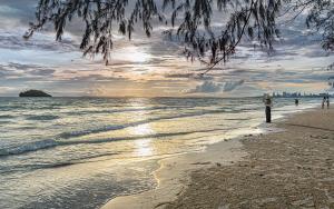 a person standing on a beach near the water at Sandy Residence Sihanoukville in Sihanoukville