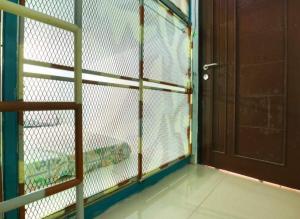 a room with a cage with a door at Kabin Kapsule UI Depok - Male Only in Jakarta