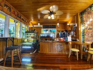 a restaurant with a counter and chairs in a room at SuanTung Coffee & Guesthouse in Chiang Rai