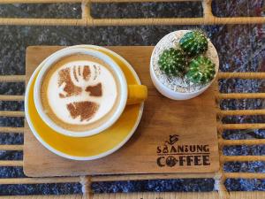 a cup of coffee and a plate of food on a table at SuanTung Coffee & Guesthouse in Chiang Rai