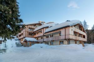 a large building with snow on the ground at Residence Civetta in Val di Zoldo